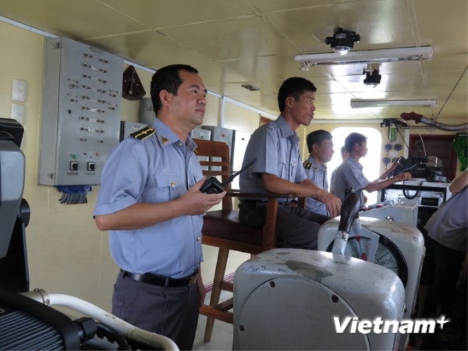 Thuyền trưởng Lê Minh Phúc (người cầm bộ đàm) và các đồng đội trên tàu kiểm ngư KN-22. (Ảnh: Quang Vũ/Vietnam+)